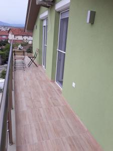 einen Balkon mit grünen Wänden und Holzböden in der Unterkunft Vila & Apartments MATEA in Gevgelija