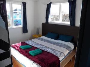 een slaapkamer met een bed met twee groene kussens erop bij The Crawford's in Invercargill