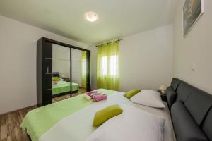 a bedroom with a large bed and a mirror at Apartman Adriatic in Ka&scaron;tela