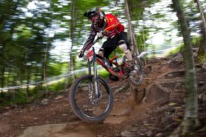 a man riding a bike down a dirt trail at Allegheny Springs in Snowshoe