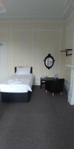 エディンバラにあるMayfair Guest Houseのベッドルーム(ベッド1台、洗面化粧台、鏡付)