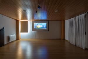 um quarto amplo com uma televisão de ecrã plano num tecto de madeira em El Castillo de Celia em Cubla