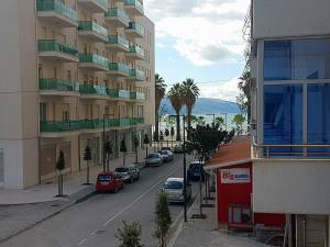 a city street with cars parked next to a tall building at Cold Water Residence in Vlor&euml;