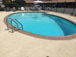 a large blue swimming pool with a rail around it at Holiday Lodge in Grass Valley