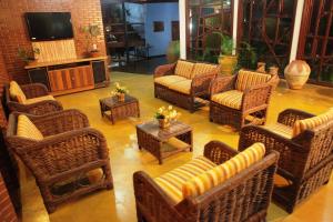 博尼圖的住宿－皮拉穆納酒店，客厅配有藤椅和电视