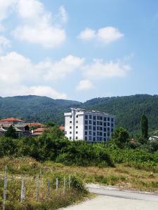 un edificio blanco al lado de una carretera en جوهرة جينارجيك, en Çınarcık