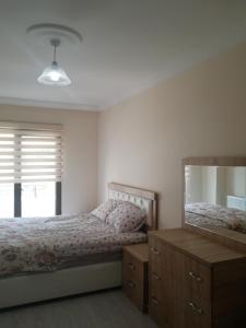 1 dormitorio con cama, tocador y espejo en جوهرة جينارجيك, en Çınarcık