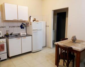 a kitchen with a table and a white refrigerator at Depto. Centrico in Corrientes