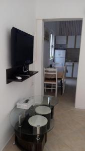 a living room with a flat screen tv and a table at Šušanj Ilino APARTMAN in Bar