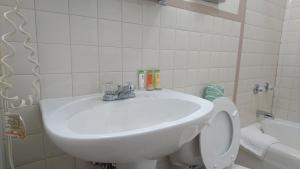 łazienka z białą umywalką i toaletą w obiekcie Heritage Inn w mieście Uniontown