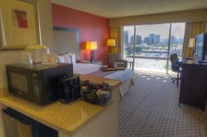 a kitchen with a table and a microwave at Ramada by Wyndham Phoenix Midtown in Phoenix