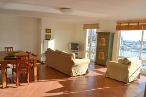 een woonkamer met een tafel en stoelen en een eetkamer bij TP Aqua Marina, Vilamoura Triplex Apartment in Quarteira