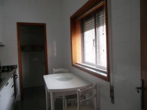 a small kitchen with a white table and a window at Afurada Apartment - 2 Room - 3 Persons in Vila Nova de Gaia