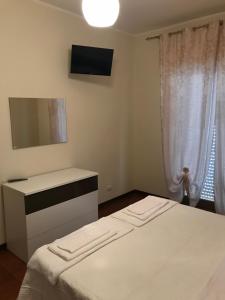 a bedroom with a bed and a dresser and a television at Residence Lamezia Golfo in SantʼEufemia Lamezia