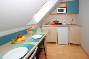 a kitchen with a table with fruits and vegetables on it at Apartamenty Dorotowo in Dorotowo