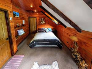 um quarto com uma cama num chalé de madeira em Refugio Las Raices em Malalcahuello