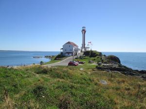 a lighthouse on a hill next to the ocean at Oceanhillside B&B in Digby