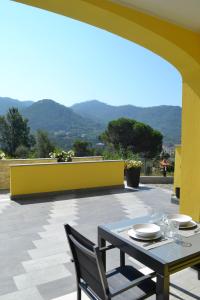 a table and chairs on a patio with mountains in the background at A Casa Mia in Levanto