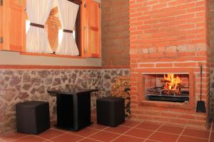 uma lareira de tijolos com uma mesa em frente em HOTEL Y CABAÑAS MOUNTAIN LODGE em Zacatlán