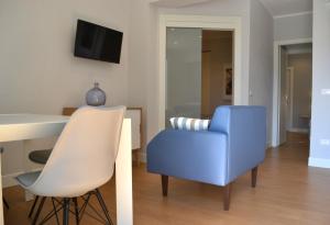 a living room with a table and a blue chair at A Casa Mia in Levanto