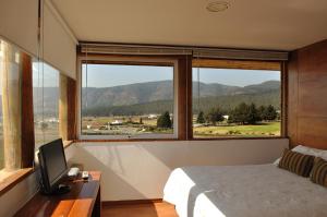 Dormitorio con ventana grande, cama y TV en Hotel Green en Marbella, en Maitencillo