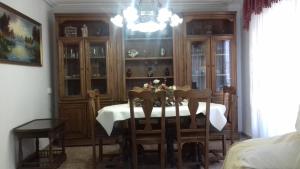 ein Esszimmer mit einem Tisch, Stühlen und einem Kronleuchter in der Unterkunft Apartamento El Misteri in Elche