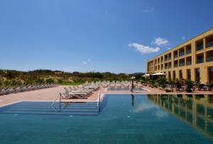a pool with lounge chairs and a hotel at Pestana Colombos Premium Club - All Inclusive in Porto Santo