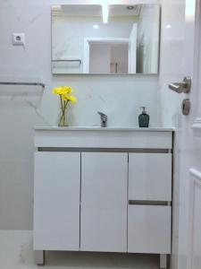 Un baño con un lavabo blanco y un espejo. en Flipflops Apartment, en Nazaré