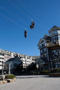 two people on a wire in front of a building at Seneca - Snowshoe in Snowshoe