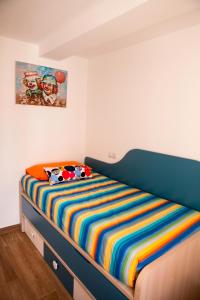 a bedroom with a bed with a colorful striped blanket at TuttiFruttiaApt in Nerja