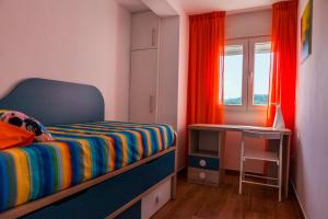 um pequeno quarto com uma cama e uma janela em TuttiFruttiaApt em Nerja