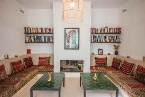 a living room with couches and bookshelves at Riad Alia in Marrakech