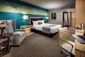 a hotel room with a bed and a chair at Downtown Grand Hotel & Casino in Las Vegas