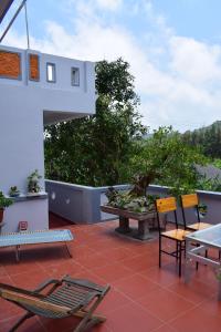 eine Terrasse mit Stühlen und einem Brunnen auf einem Gebäude in der Unterkunft Cat Ba Sweet Potato Homestay in Cát Bà