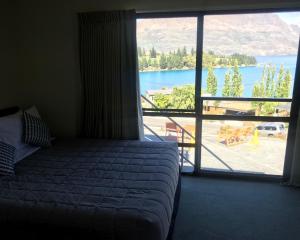 a bedroom with a bed and a view of a lake at Earnslaw Lodge in Queenstown