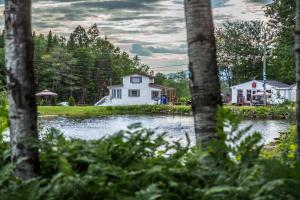 una casa in mezzo a un lago con alberi di Chalets Lac Beauport a Lac-Beauport