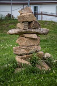 a stack of rocks sitting in the grass at Chalets Lac Beauport in Lac-Beauport