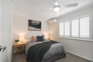 a bedroom with a large bed and a window at Renovated Moololaba Unit 100m To Beach in Mooloolaba