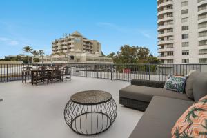 a patio with a couch and a table and chairs at Renovated Moololaba Unit 100m To Beach in Mooloolaba