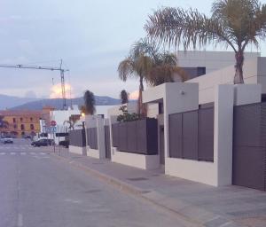 トレ・デル・マールにあるChalet Los Jarronesの椰子の木が並ぶ道脇の柵