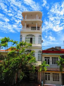 a white building with a tower on top of it at Nam Long Hotel in Dong Hoi
