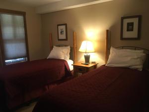 a hotel room with two beds and a lamp at Taynton Lodge at Panorama Mountain Village Resort in Panorama