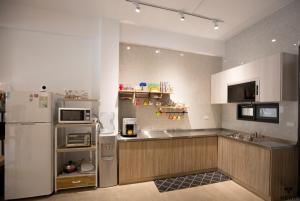 a kitchen with a white refrigerator and a sink at NEAR B&b 2283 in Hualien City