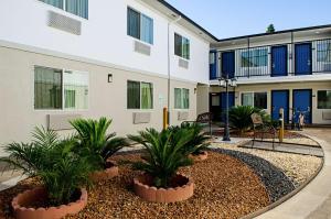 un edificio con plantas delante de él en Motel 6-Modesto, CA - Downtown en Modesto