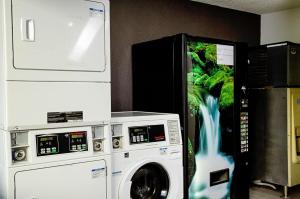 uma máquina de lavar roupa e um aquário num quarto em Motel 6-Modesto, CA - Downtown em Modesto