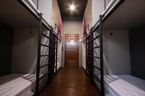 - un couloir avec 3 lits superposés et une porte dans l'établissement Tian Tian Hostel, à Bangkok