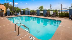 a swimming pool at a resort with chairs and tables at Best Western Commerce Inn in Commerce