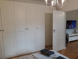 a bedroom with white cabinets and a bed and a tv at 2 Bedroom City Center Apartment in Katowice