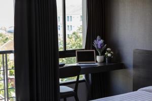 a room with a desk with a laptop and a window at @S115 Residence in Samutprakarn