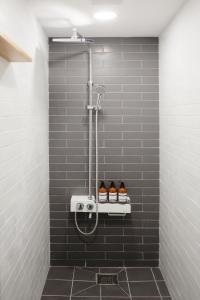 a bathroom with a shower with shoes on a shelf at The Cube Hotel in Seoul +71 photos